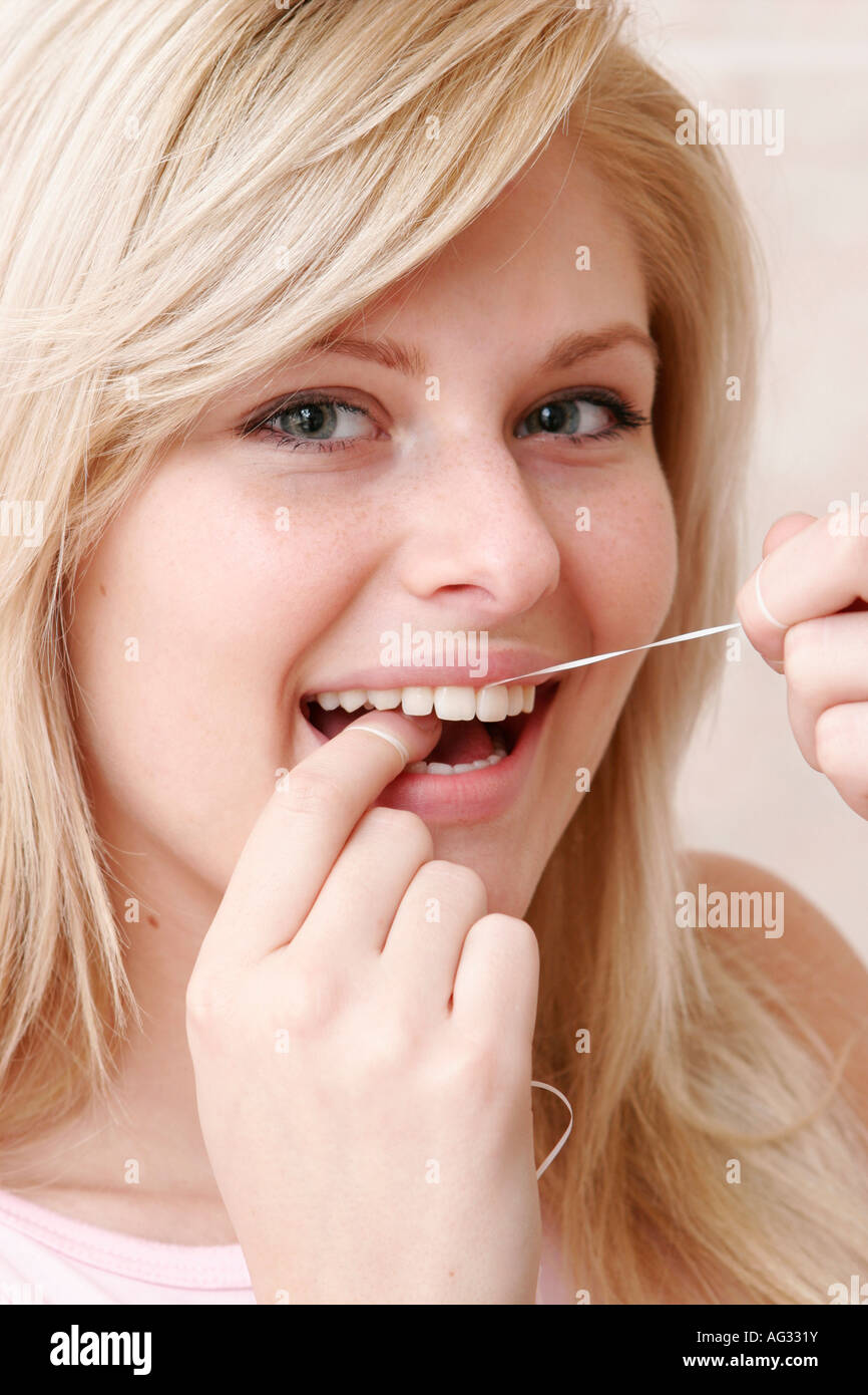 A young woman is using dental floss Stock Photo Alamy