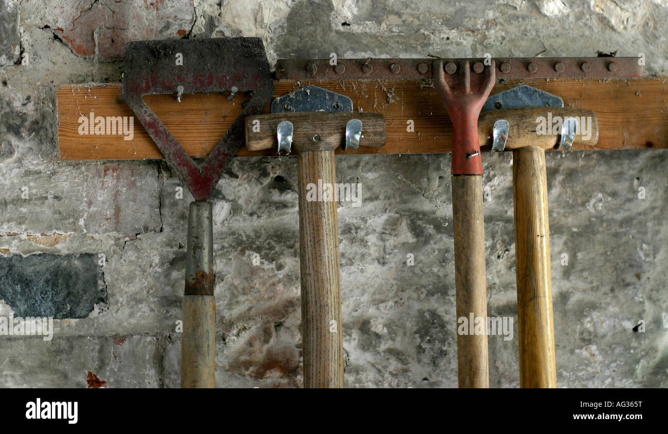 garden tools on a rack, hoe, spade, rake, fork, wooden handle, peg