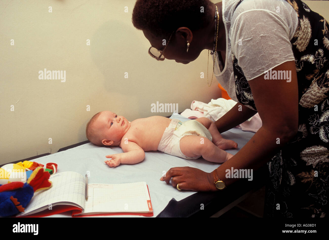 Health visitor doing post natal eight week developmental check on baby