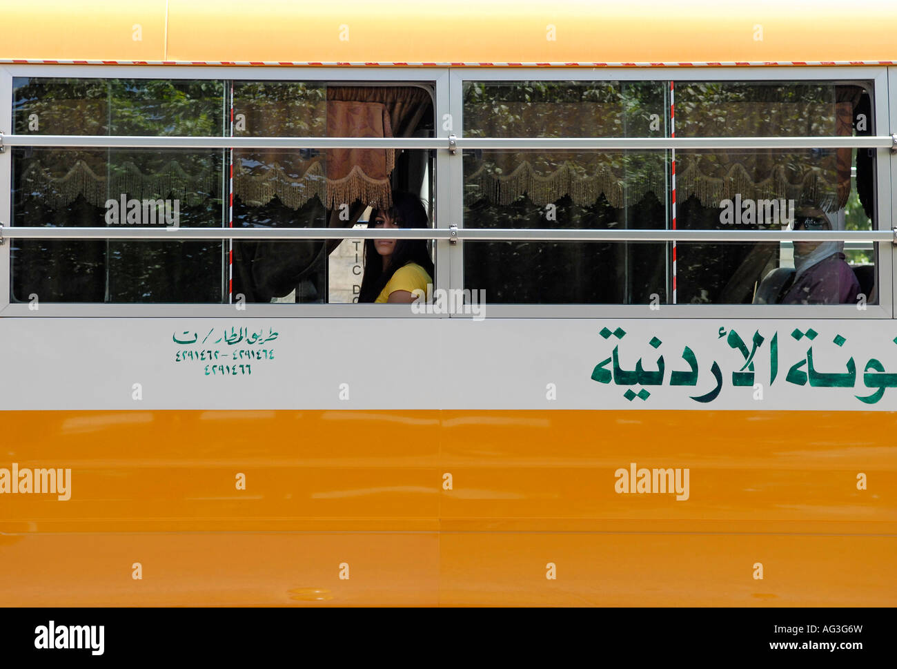 Jordanian women peer out the window of a bus in Amman Jordan Stock Photo