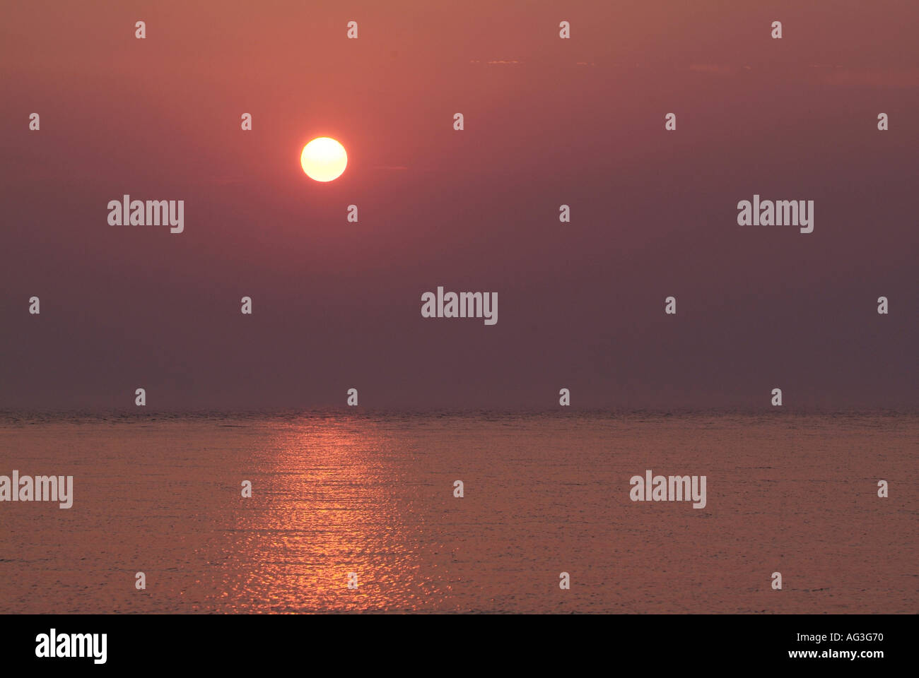 Sunset over water on Lake Michigan at Manistee Michigan beach Stock Photo