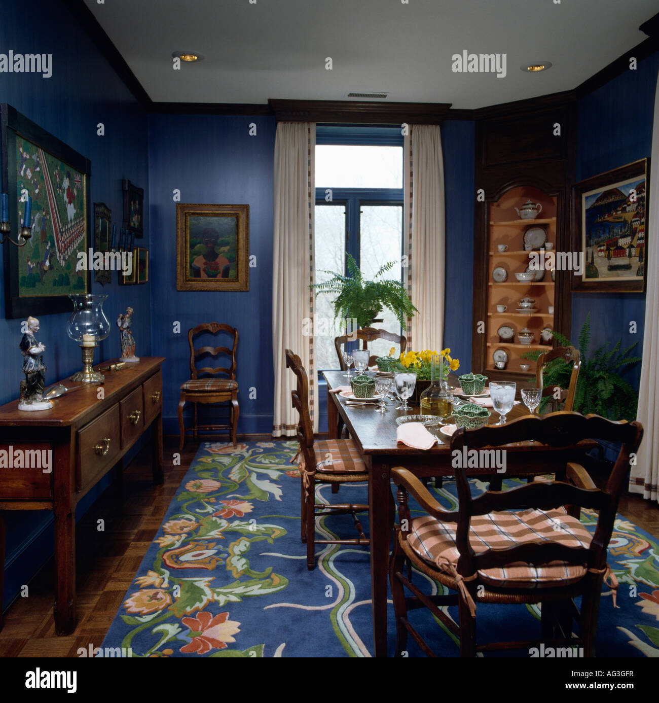 Patterned blue carpet and mahogany table and chairs in blue eighties diningroom Stock Photo Alamy