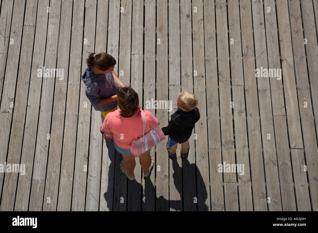 People standing on wooden dock taken from above Stock Photo