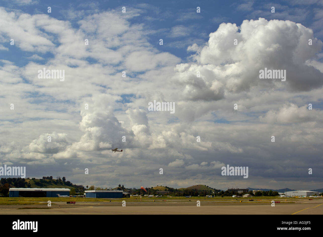 Small Cessna single engine airplane taking off into blue sky and clouds ...