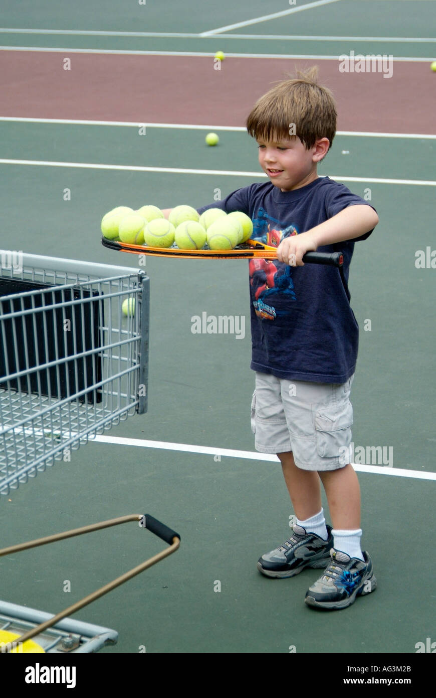 4 and 5 year old children take group tennis lessons taught by college  students at a public tennis court Stock Photo - Alamy