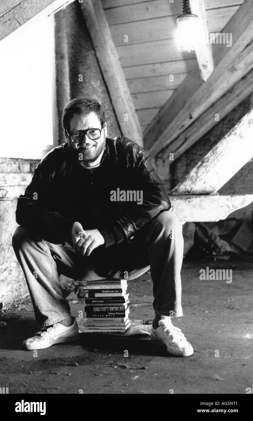 Middendorf, Klaus, * 1944, German author / writer, full length, sitting on pile of books, early 1990s, Stock Photo