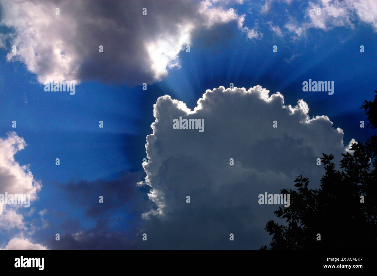 Sunshine shining behind white clouds Stock Photo