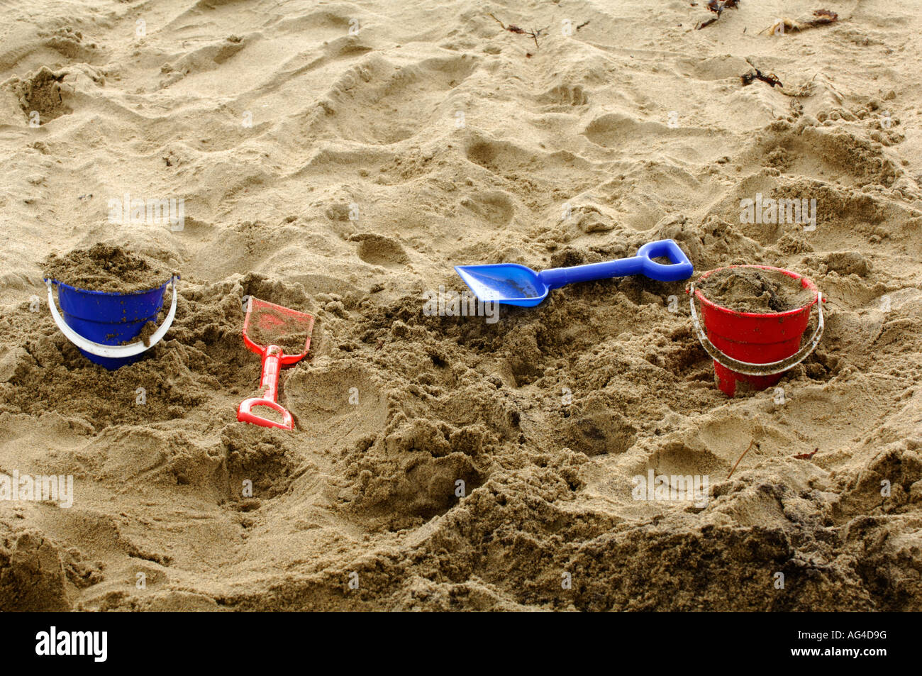 plastic buckets and spades laid on beach in the sand Stock Photo Alamy