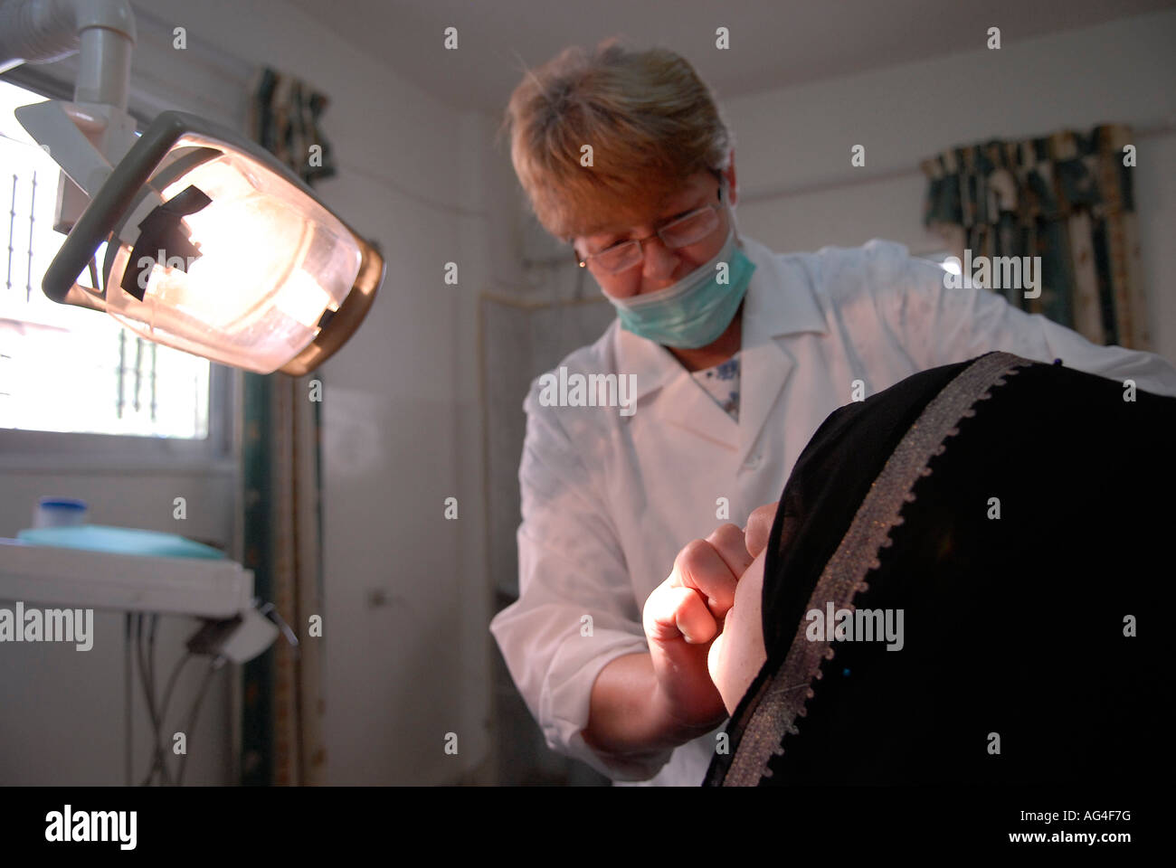 A Russian dentist treats an Iraqi refugee at a dental clinic operated