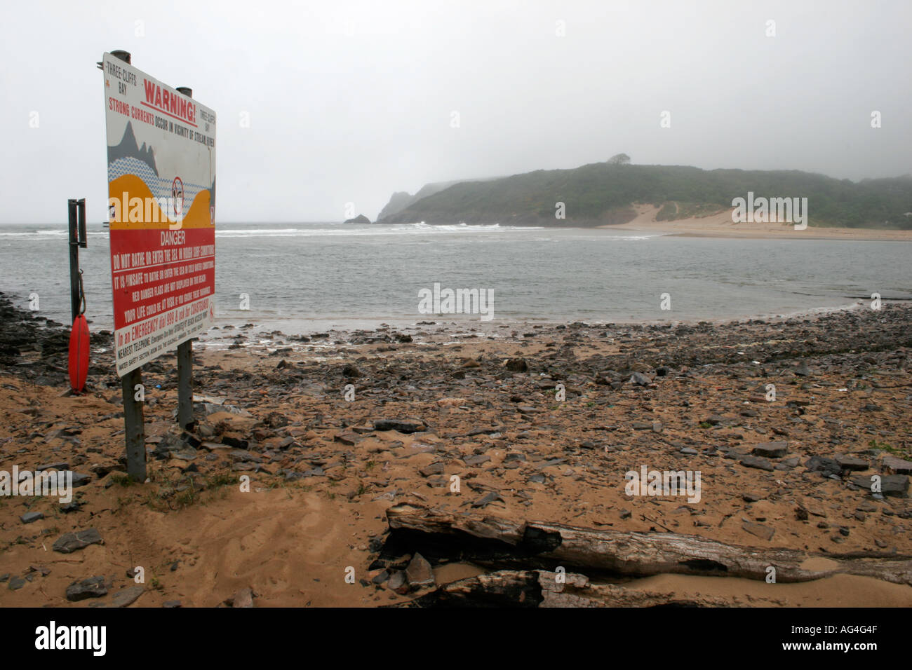 Sign Warning of Dangerous Currents - HIGH TIDE AT THREE CLIFFS BAY, GOWER PENINSULA, SOUTH WALES, U.K. Stock Photo