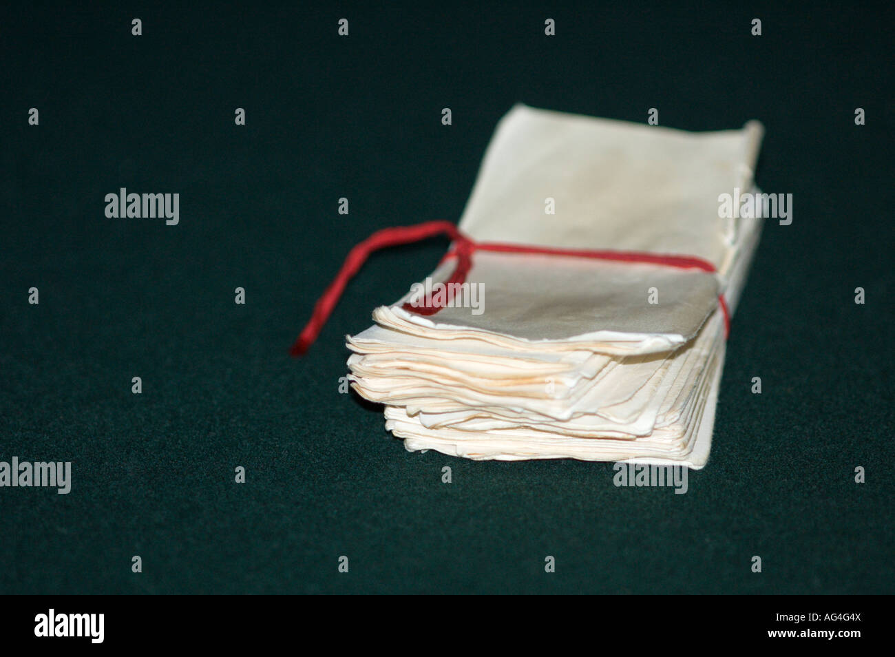 White Ballots on Green Felt Background Tied with a Red Cord Stock Photo