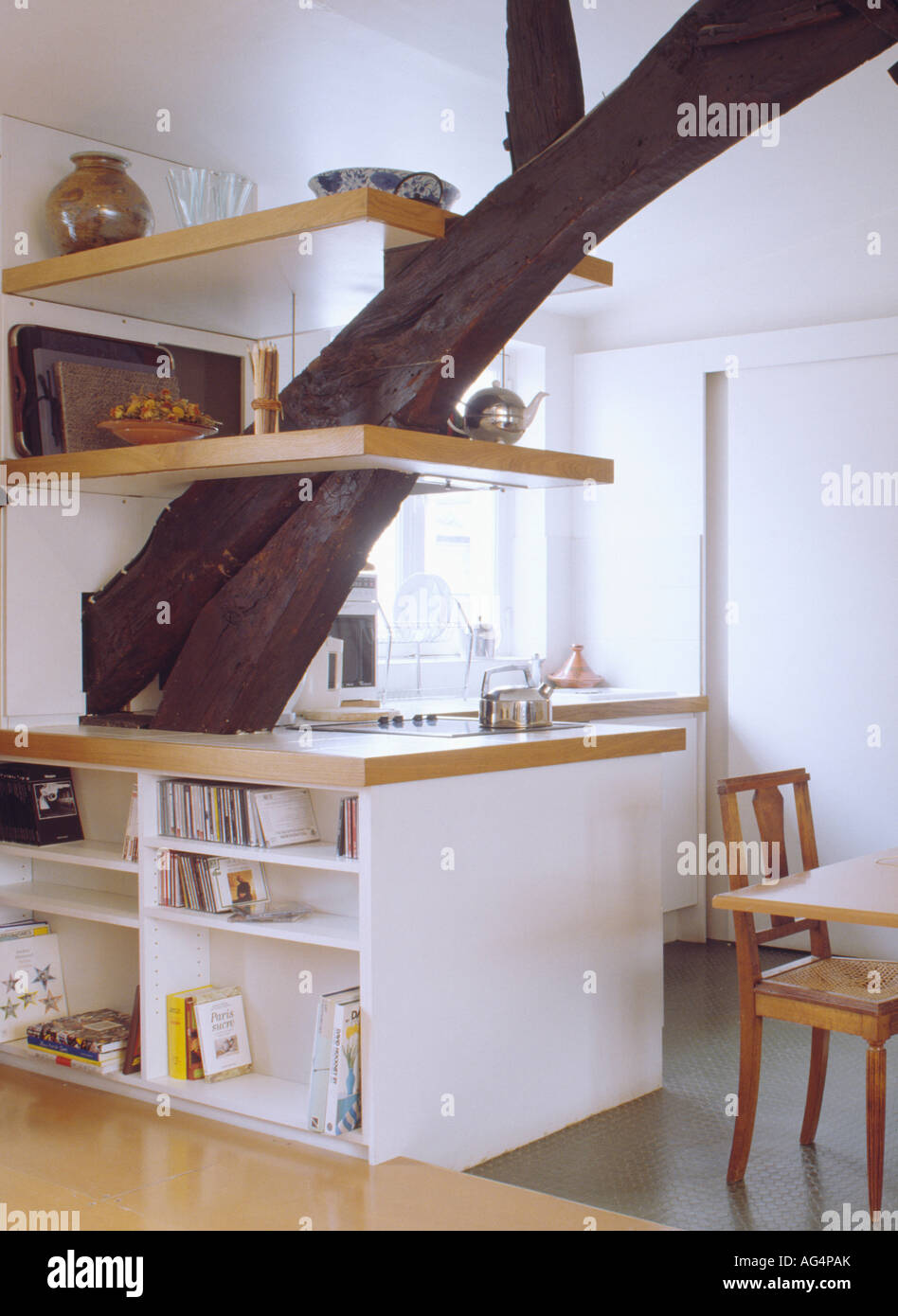 Shelves on large supporting beam in modern white loft kitchen with fitted units Stock Photo