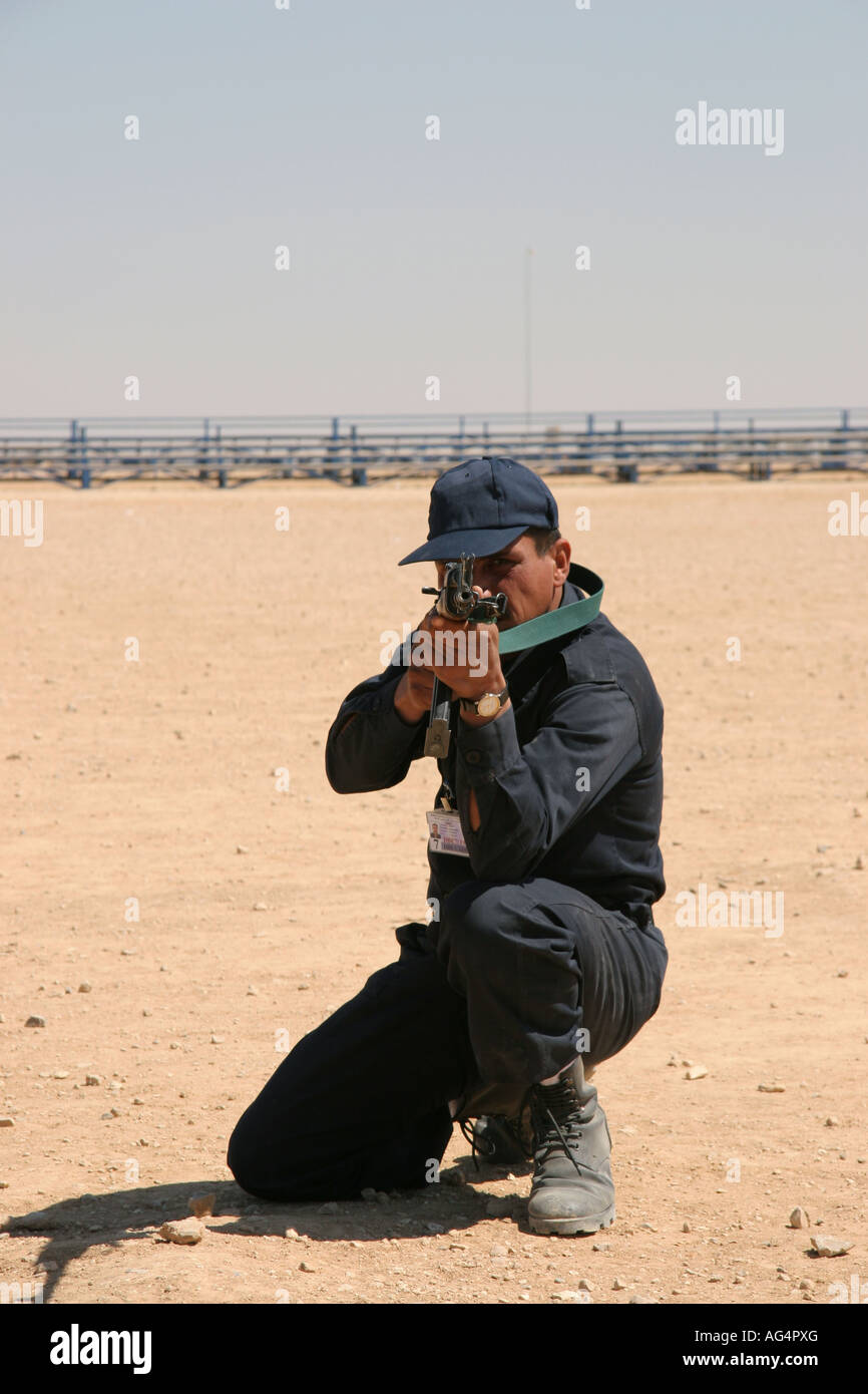 Iraqi poice officer kneeling with AK47 Stock Photo
