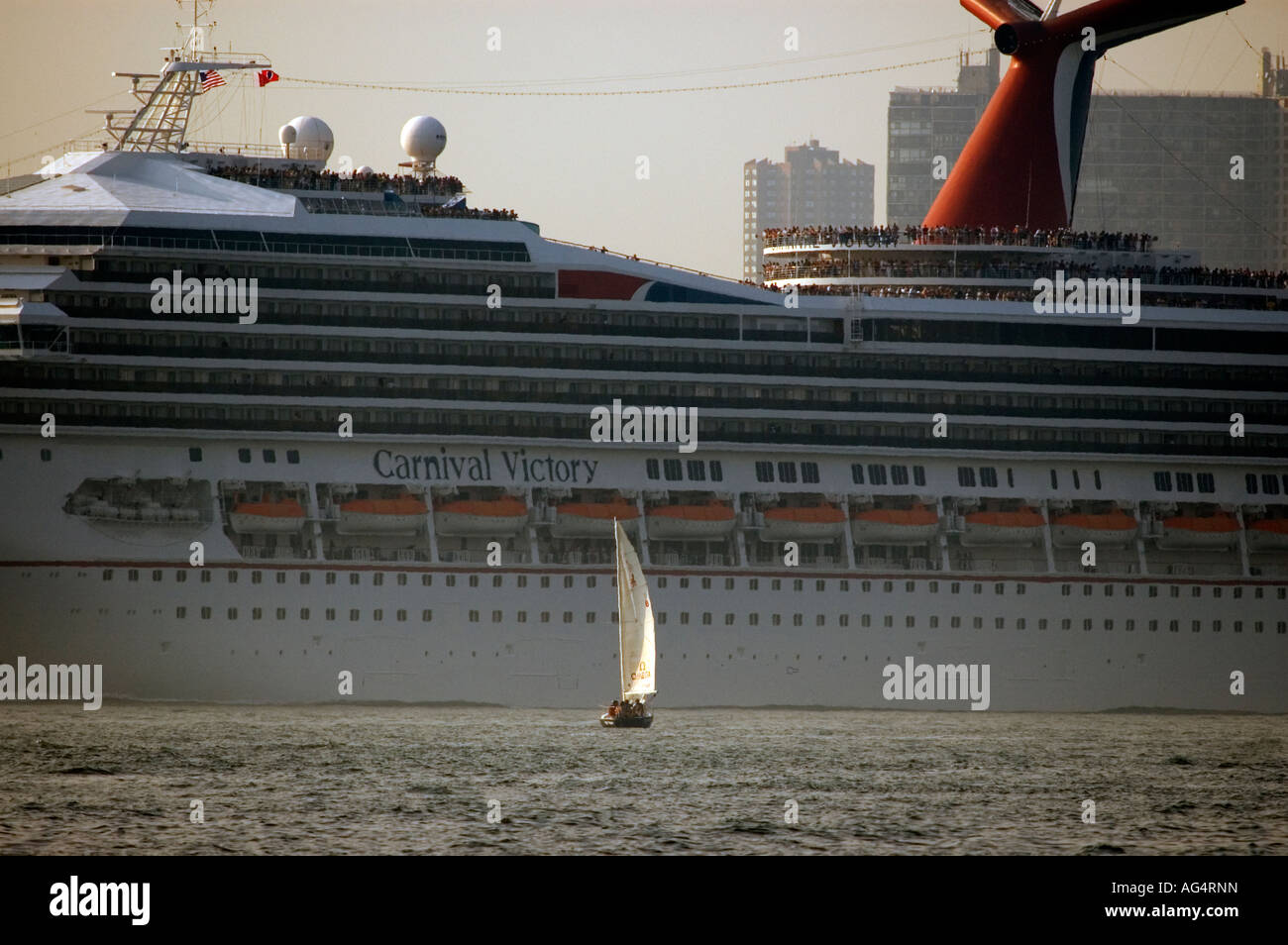 The Carnival Victory cruise ship passes a sailboat on it s way out of NY harbor Stock Photo