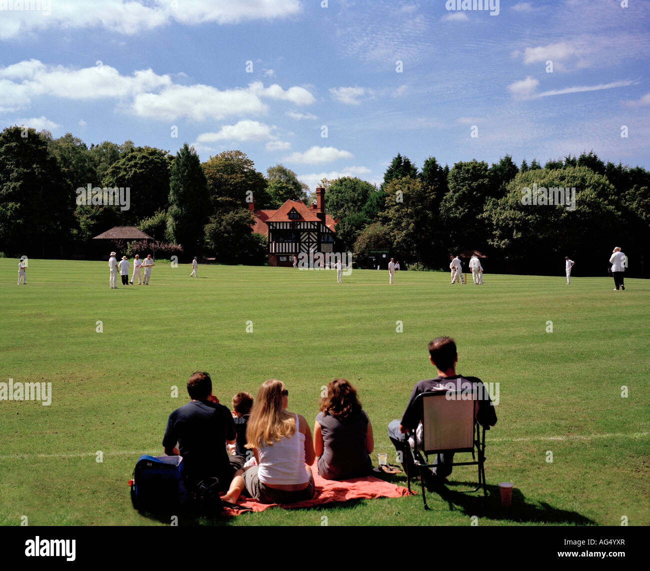 Family watching a game of village cricket Tilford Green, Surrey, England, UK. Stock Photo