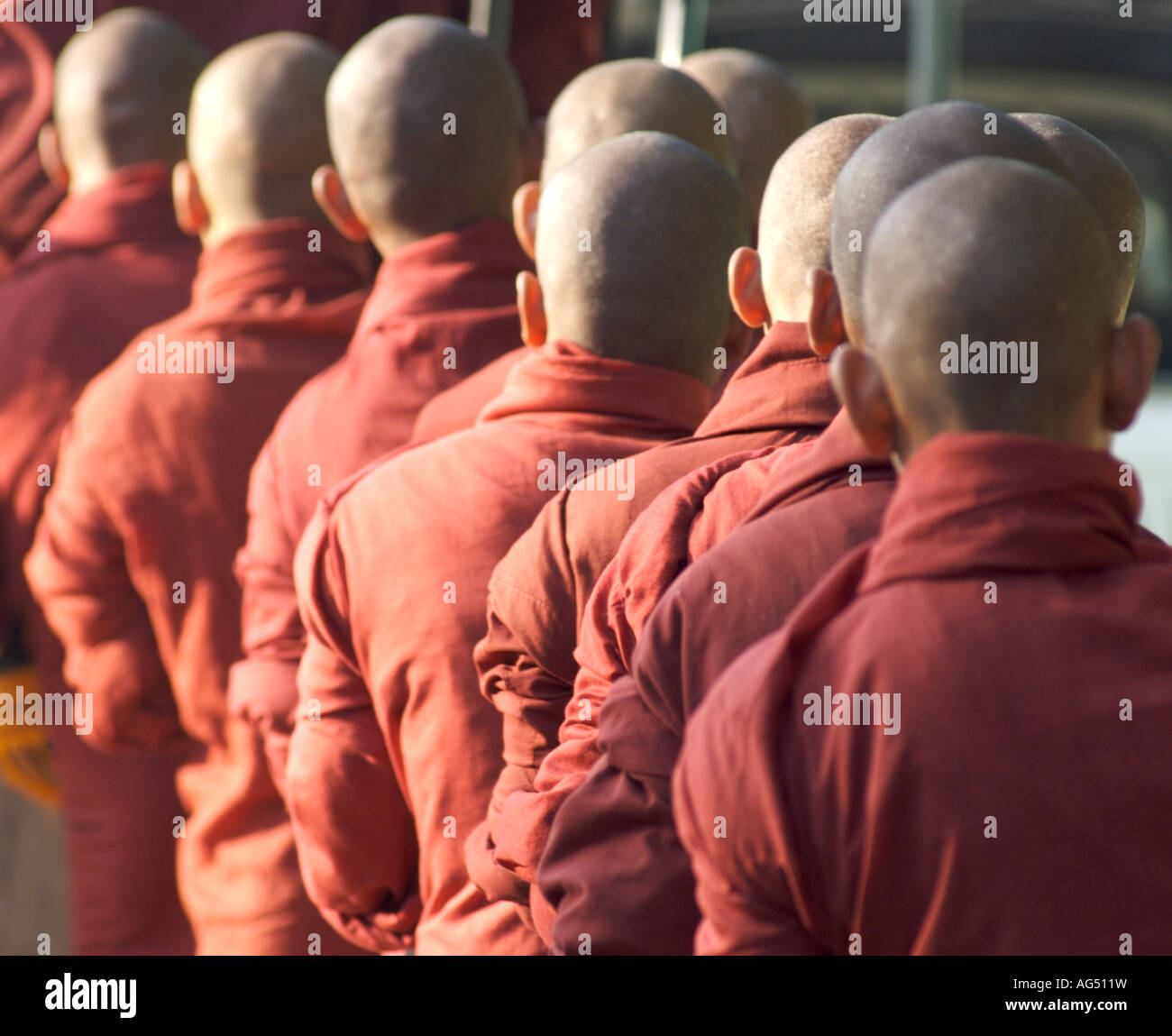 Buddhist monks with shaved heads lined up in a procession in the temples of Bagan in Myanmar formerly Burma Stock Photo