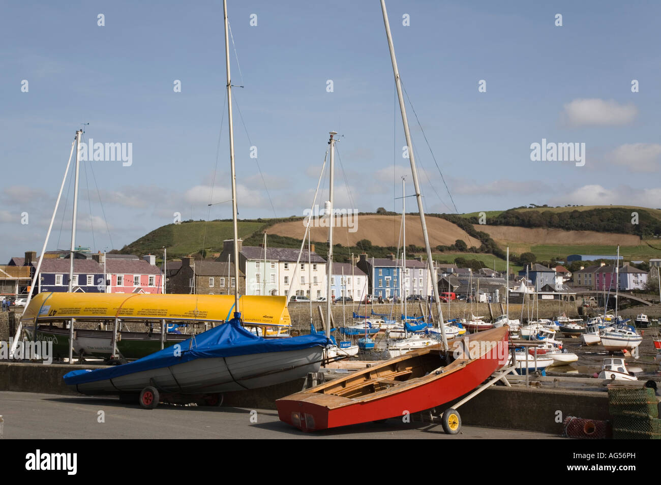Boats on quay by Yacht Club with harbour and quayside houses beyond in