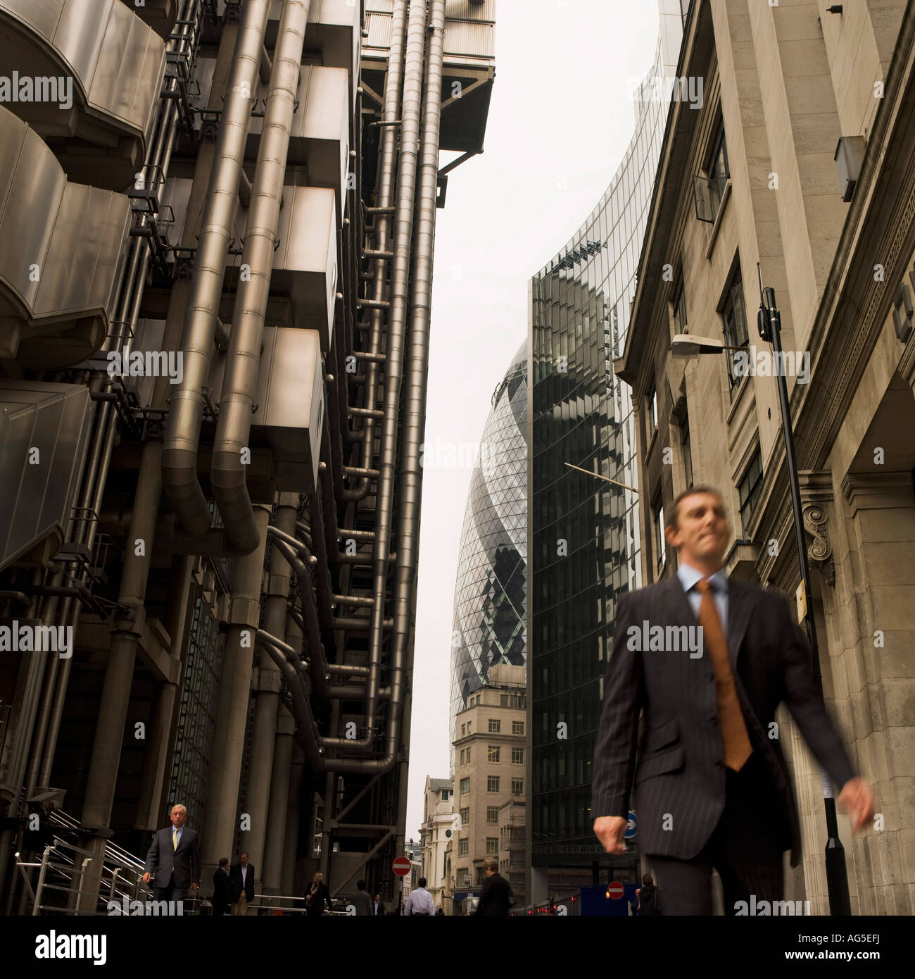 City worker businessman walking past Lloyds London England UK Stock Photo