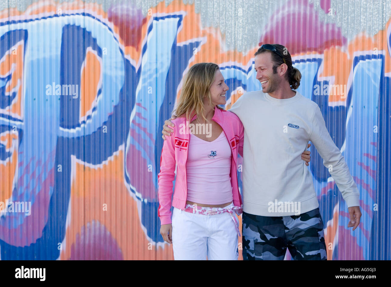 Couple talking and flirting leaning on wall Stock Photo