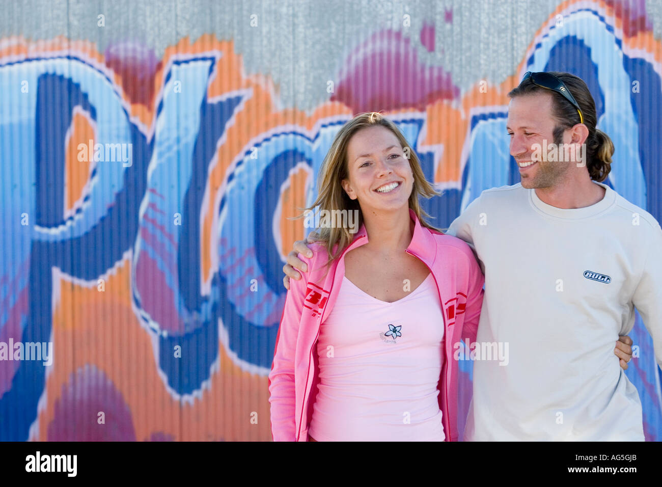 Couple talking and flirting leaning on wall Stock Photo