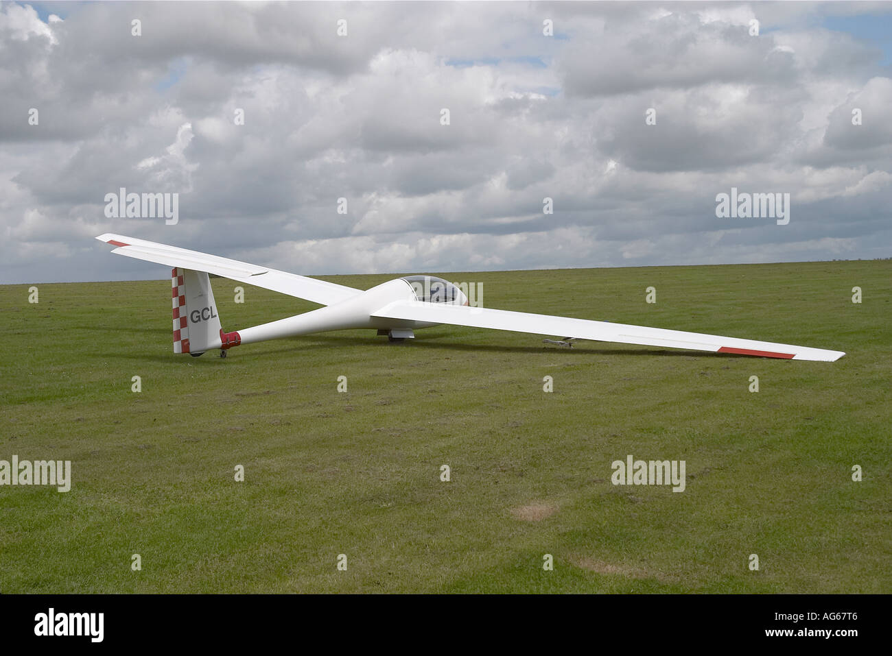 Sleek Single white glider parked on grass in private airfield Stock Photo