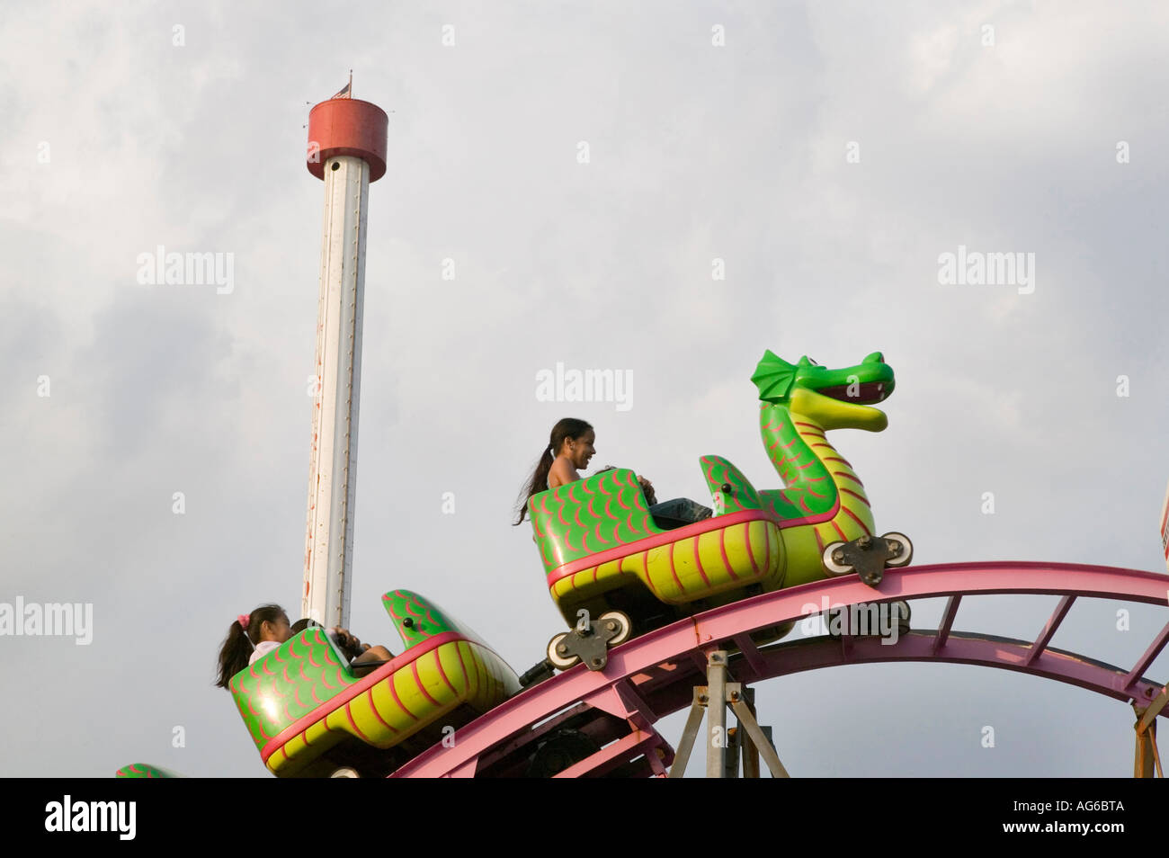 Girl riding a dragon car on a small roller coaster ride at Coney Island
