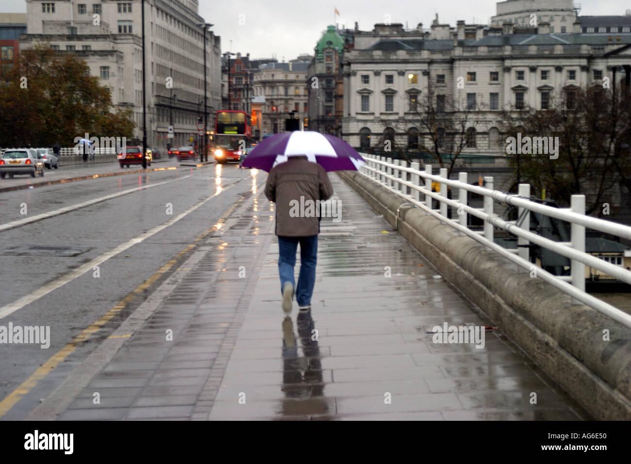 Single person walking over Waterloo Bridge in London in the rain Stock Photo