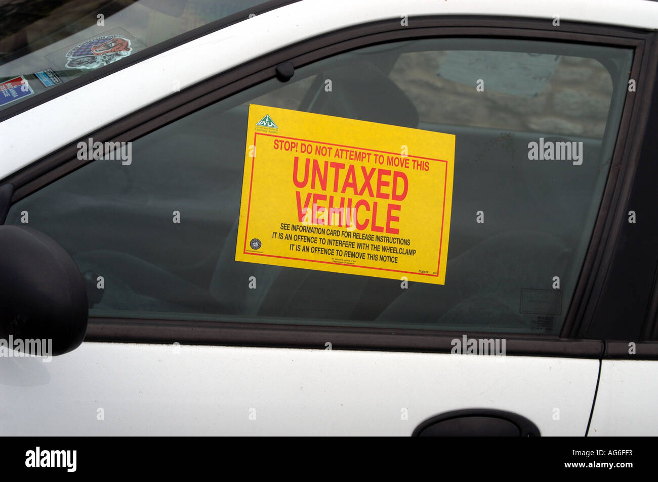 White car with DVLA wheel clamp and notice Stock Photo Alamy