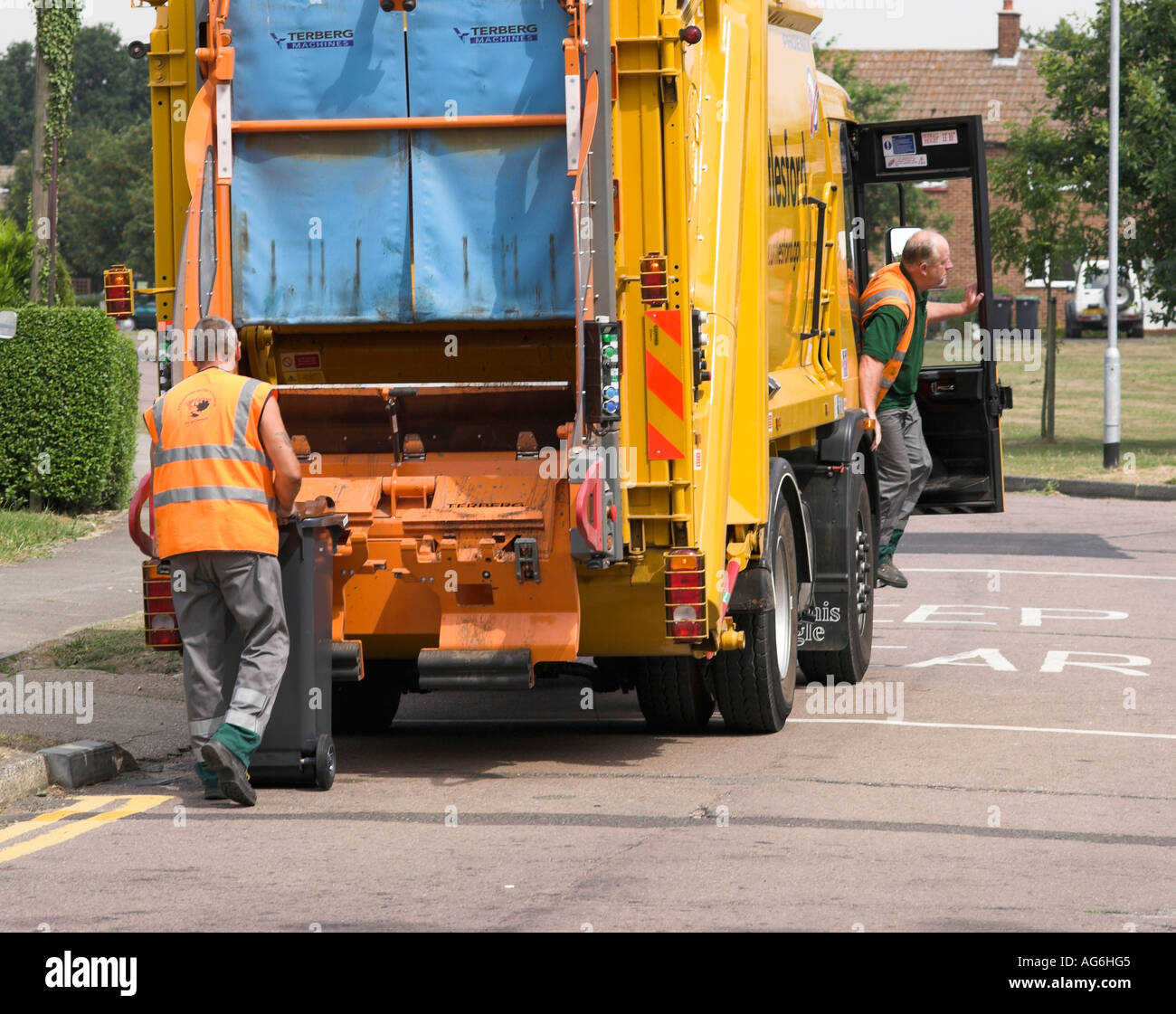 Dustbin men collect rubbish from outside homes in Hatfield Heath in Essex, England. Stock Photo