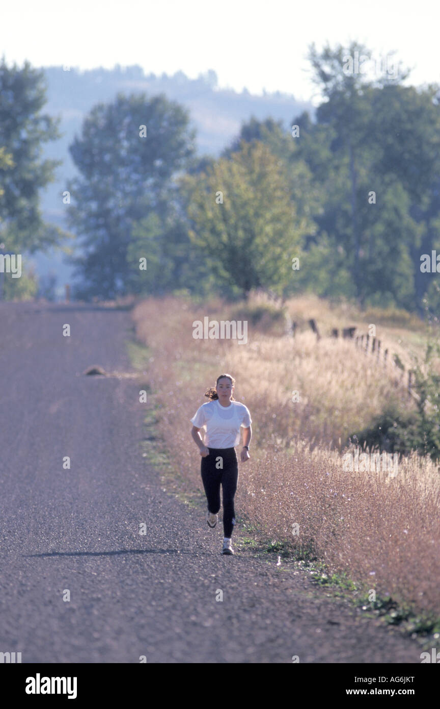 Caucasian Woman Jogging Along A Gravel Country Road Stock Photo Alamy