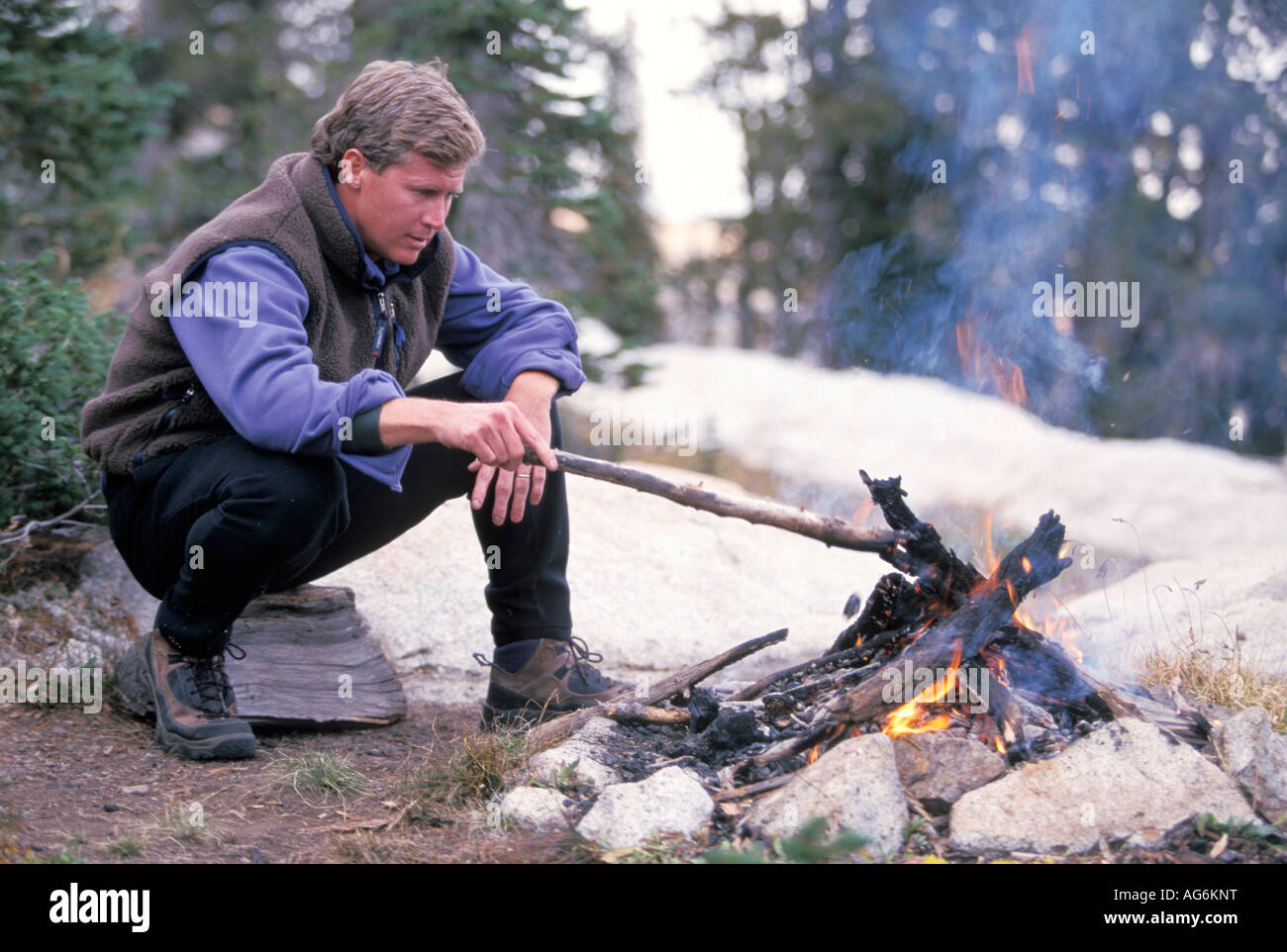 Man stoking a fire hires stock photography and images Alamy