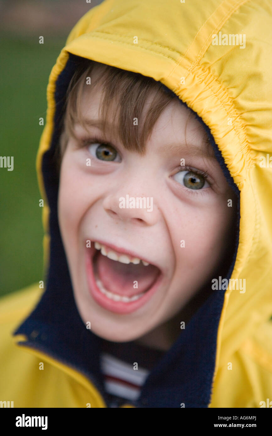 cute five year old boy smiling with yellow rain jacket on, rainy day Stock Photo Alamy