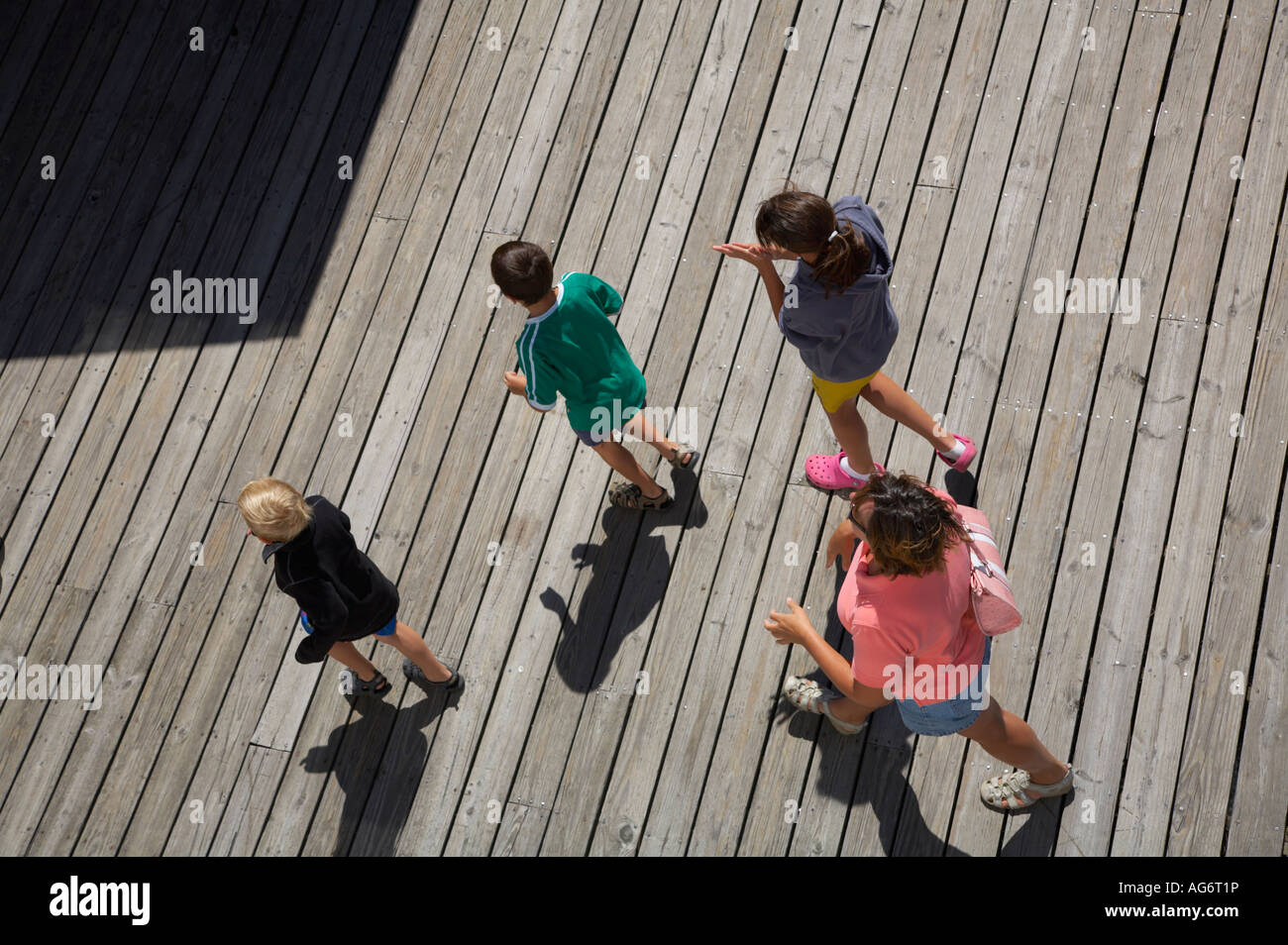 People walking on wooden dock taken from above Stock Photo