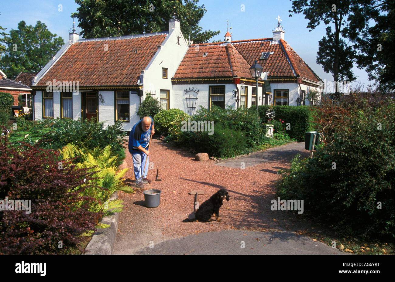 Netherlands Bedum Senior man sweeping path Stock Photo