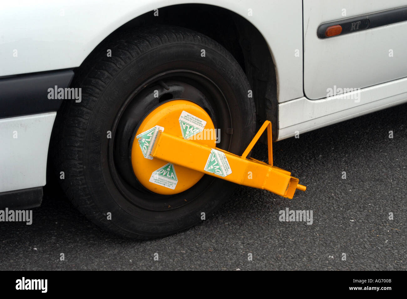 White car with DVLA wheel clamp and notice Stock Photo Alamy