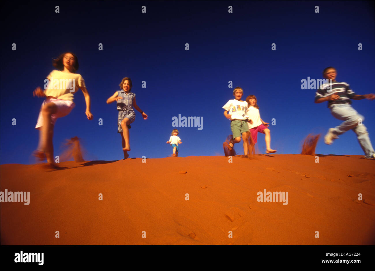children run down a sand dune windorah Queensland 1837 Stock Photo