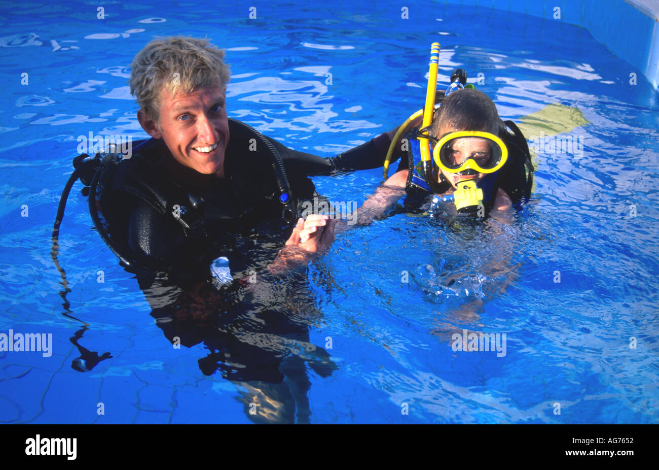Instructor and boy trying scuba diving in a swimming pool Sharm el