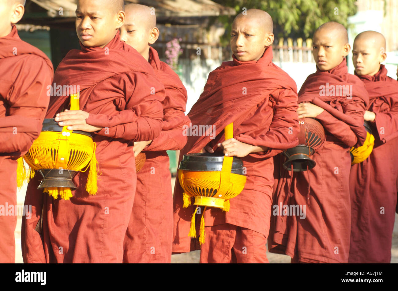 Buddhist monks with shaved heads lined up in a procession in the temples of Bagan in Myanmar formerly Burma Stock Photo