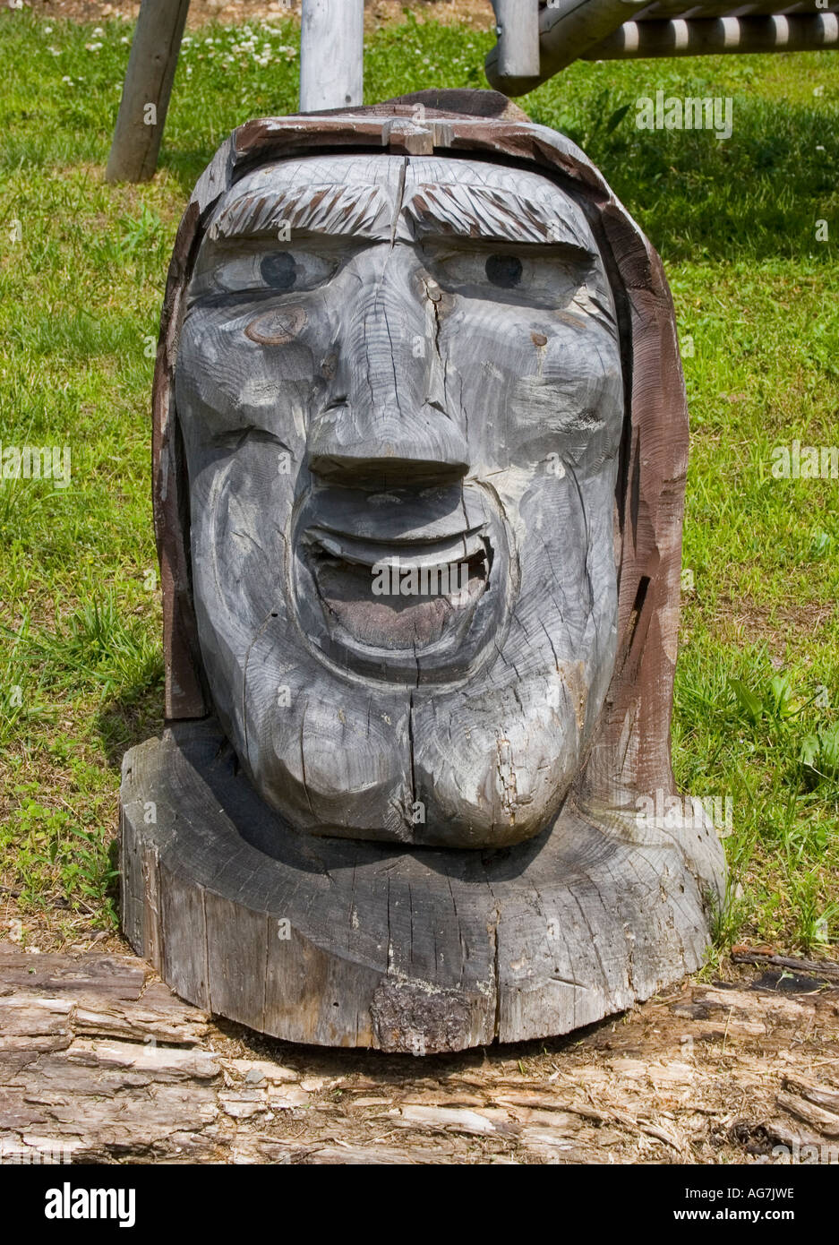 Hand carved wooden face with a cleft chin at front the Timberland