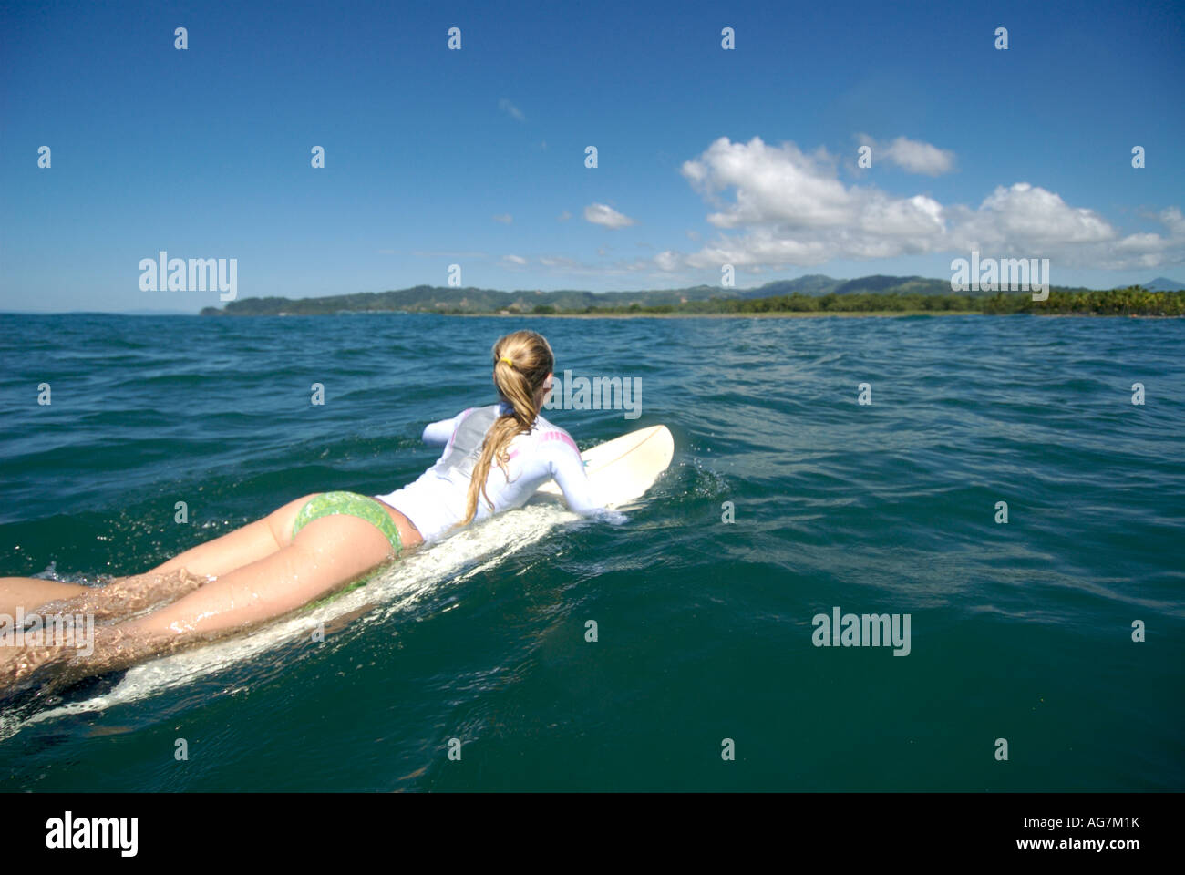 Blonde woman lying on a surfboard Stock Photo