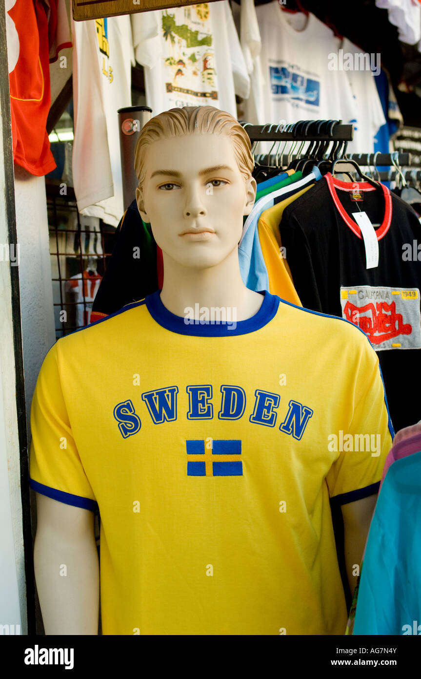 Male manequin in street market wearing bright yellow shirt with 'Sweden' and Swedish flag printed on it. Stock Photo