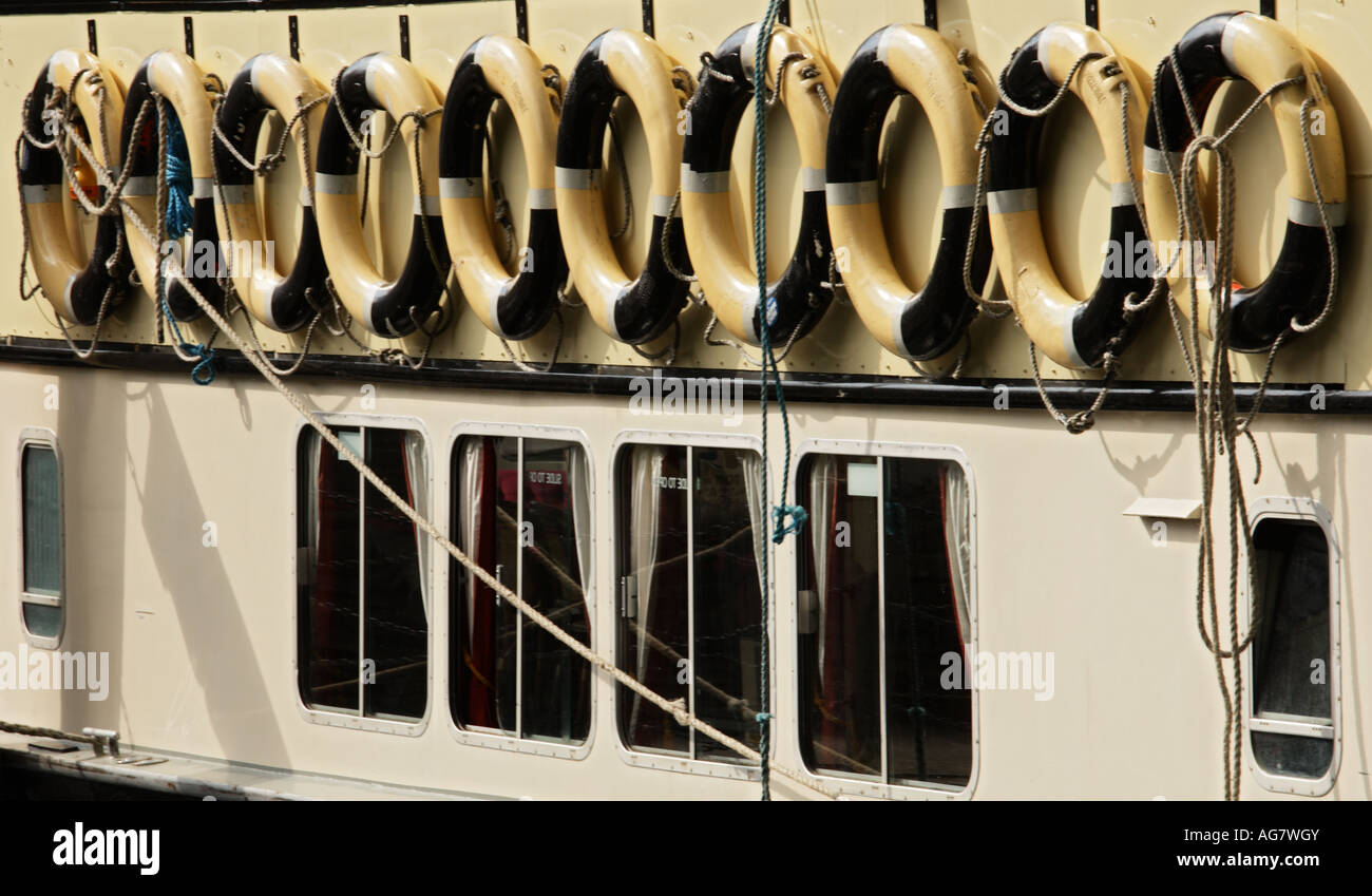 Lifebuoys hanging in a row over windows of boat Stock Photo