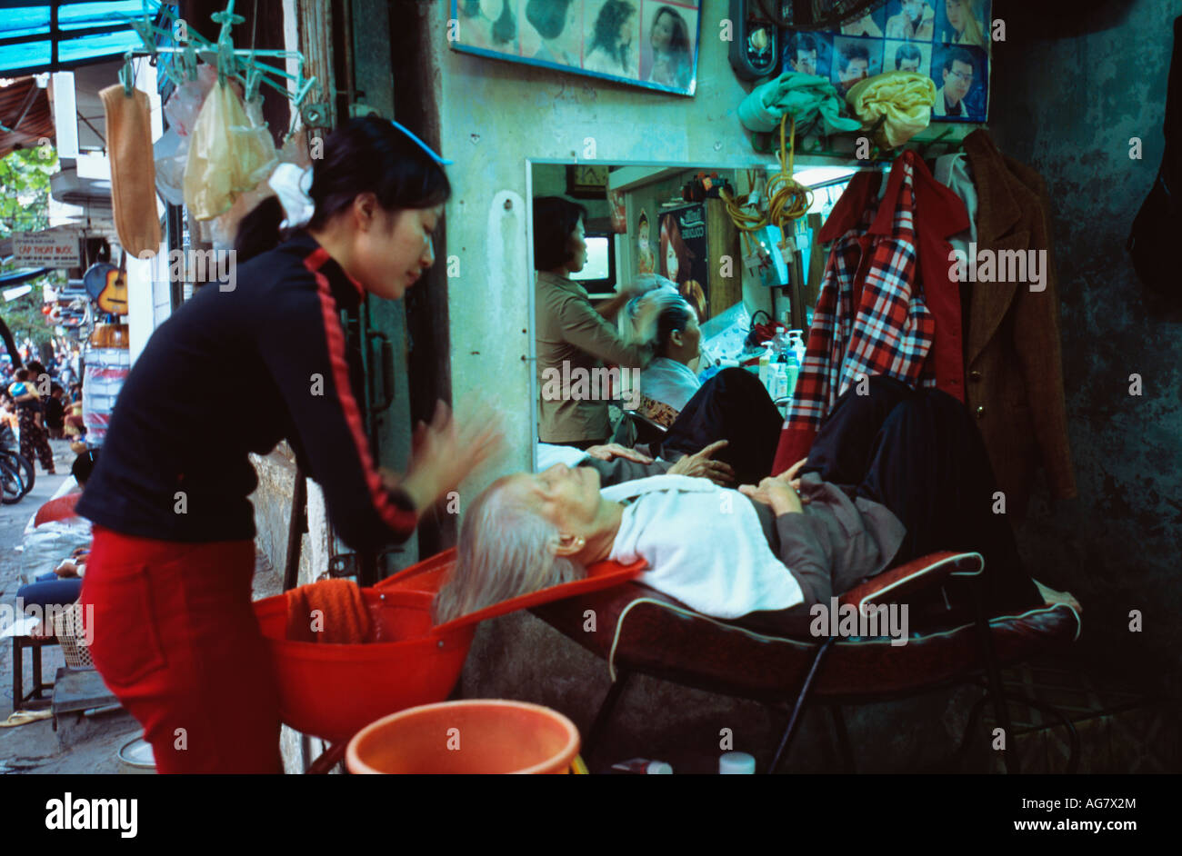 Vietnam Hanoi Hairdresser massaging to senior woman Stock Photo