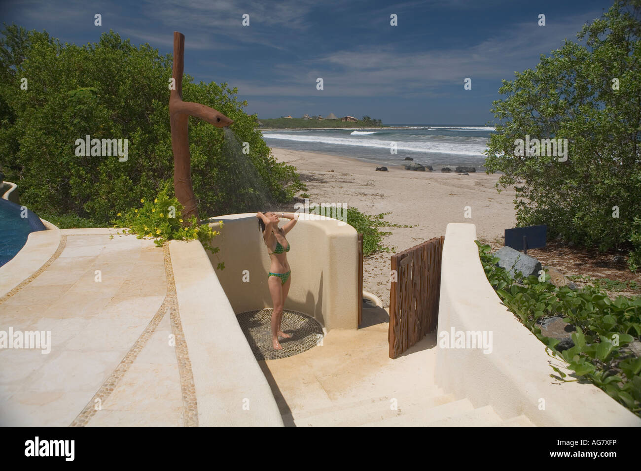 Woman takes a shower next to the beach,Manzanillo Bay, Troncones, Ixtapa Zihuatanejo area State of Guerrero, Mexico. Stock Photo