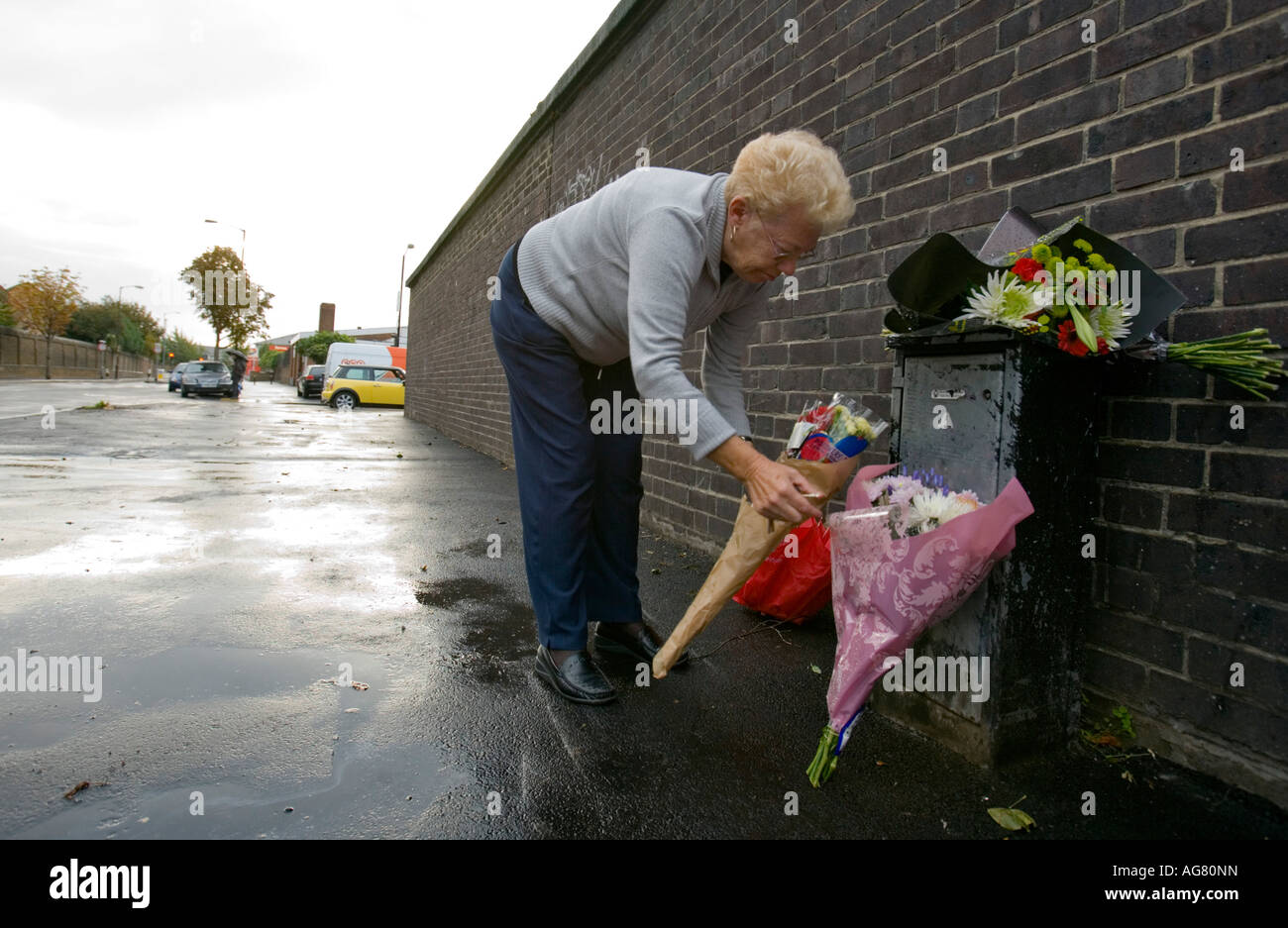 Mourner leaving flowers at the scene of a murder Stock Photo Alamy