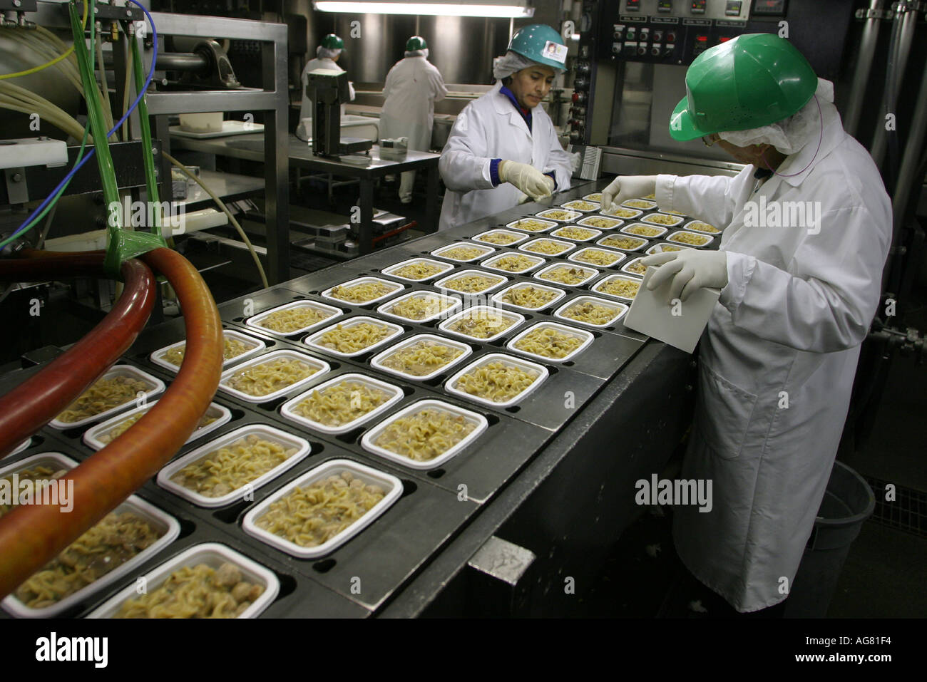 A group of workers at a food processing plant check prepared