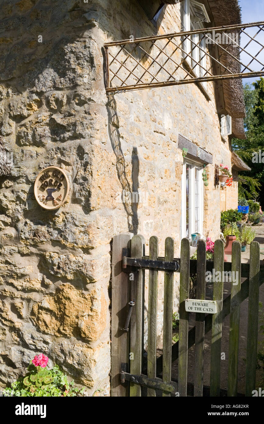 'Beware of the cats' sign on the gate of The Old Forge in the Cotswold village of Hidcote Bartrim, Gloucestershire Stock Photo