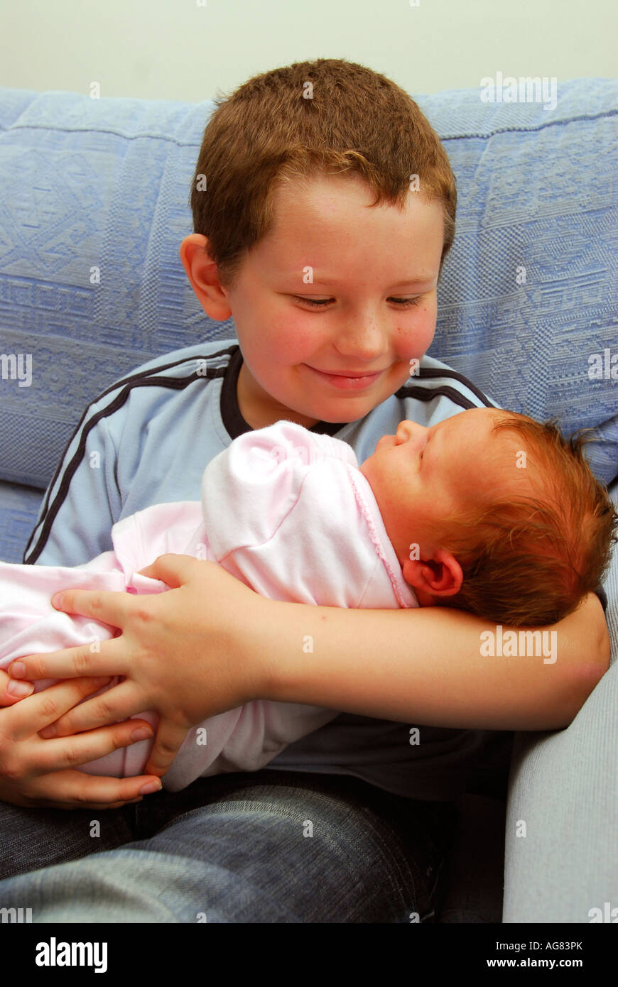 8 year old boy cradling his newborn 4 day old sister, Middlesex, UK Stock Photo Alamy
