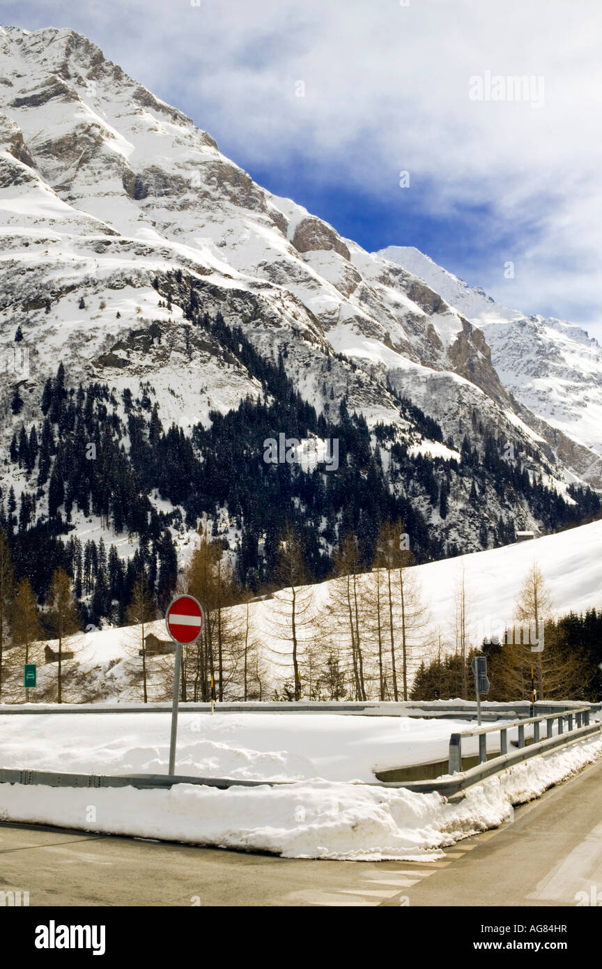 Snowy mountain scene with no entry sign on road Stock Photo