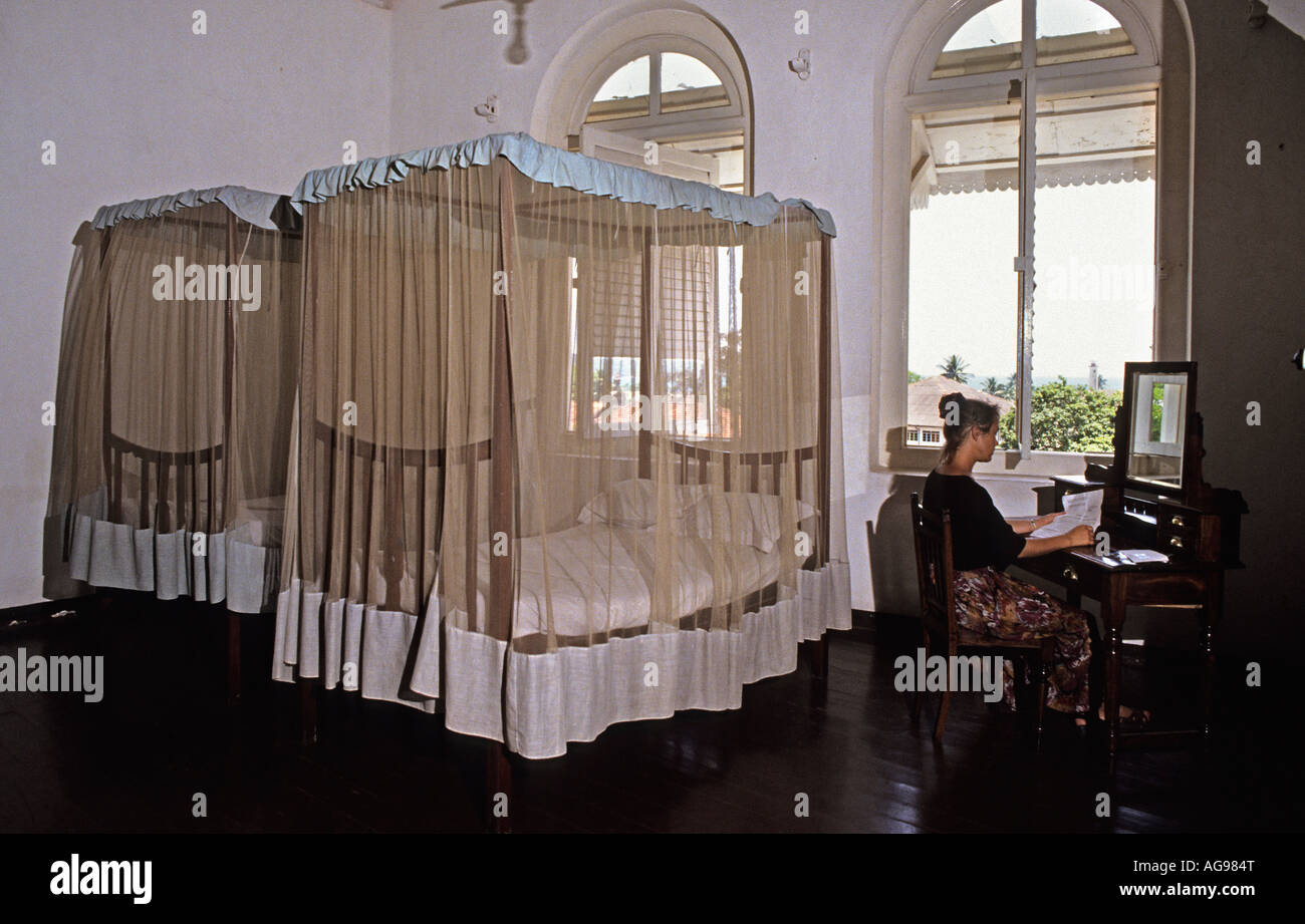 Sri Lanka Galle, Young woman sitting in bedroom of New Oriental Hotel Stock Photo